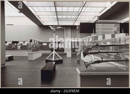 Raum mit Musketen und Pistolen in Vitrinen, in der Mitte ein Vogel auf einem Holzstandard; Ausstellung von Musketen und Pistolen. Auf dem Foto eine Rekonstruktion eines hölzernen Vogels (Papagei), wie er im 17. Jahrhundert bei Schießspielen verwendet wurde. Herstellung der Herman Halskette, Restauratorin im Rijksmuseum. Stockfoto