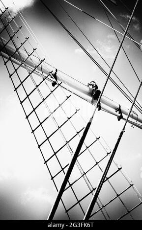 Man kommt auf einem traditionellen quadratischen Segelschiff hoch Stockfoto