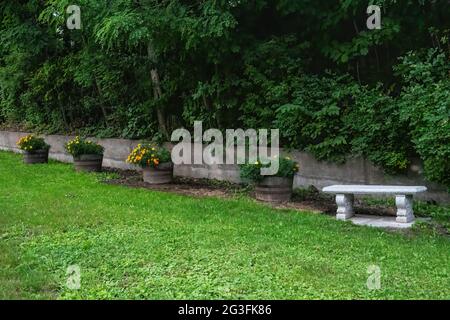 Ruhestätte mit einer Bank und Töpfen von Ringelblumen auf einem Weg auf einem sehr steilen Hügel an der First St. in Taylors Falls, Minnesota USA. Stockfoto