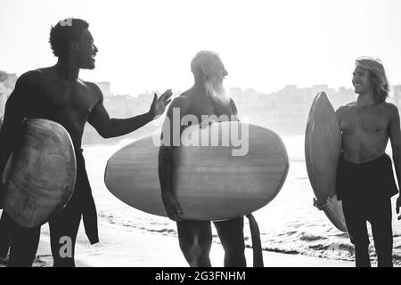 Multi-Generationen-Surfer Männer mit Spaß am Strand - Fokus auf Silhouetten Stockfoto