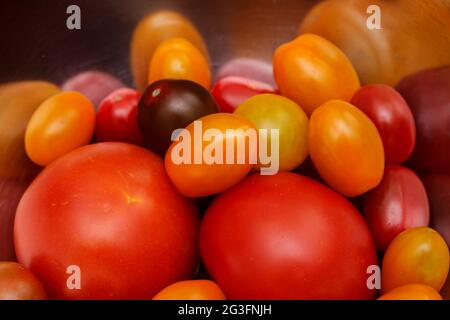 Verschiedene Farben und Größen von Tomaten in einer Metallschale Stockfoto