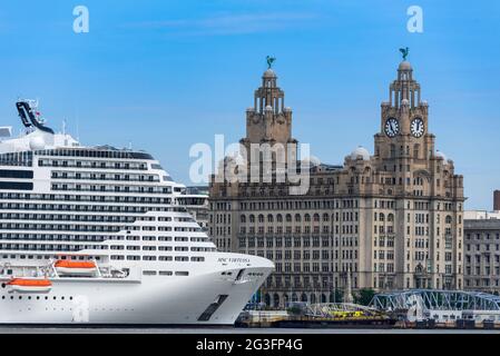 Der Kreuzfahrtdampfer MSC Virtuosa liegt am Liverpooler Kreuzfahrtterminal am Fluss Mersey vor dem Gebäude der Roayal Liver. Stockfoto