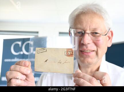 Bietigheim Bissingen, Deutschland. Juni 2021. Christoph Gärtner, Geschäftsführer des Christoph Gärtner Auktionshauses, hält den Umschlag mit der Marke "Red Mauritius" auf der Pressekonferenz zur Auktion in der Hand. Der '1847 Mauritius 1d Ball Cover' Umschlag ist einer der drei teuersten philatelistischsten Artikel der Welt. Der Startpreis bei der Auktion am 26. Juni 2021 in beträgt vier Millionen Euro. Quelle: Bernd Weißbrod/dpa/Alamy Live News Stockfoto