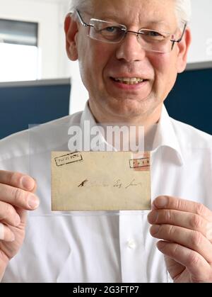 Bietigheim Bissingen, Deutschland. Juni 2021. Christoph Gärtner, Geschäftsführer des Christoph Gärtner Auktionshauses, hält den Umschlag mit der Marke "Red Mauritius" auf der Pressekonferenz zur Auktion in der Hand. Der '1847 Mauritius 1d Ball Cover' Umschlag ist einer der drei teuersten philatelistischsten Artikel der Welt. Der Startpreis bei der Auktion am 26. Juni 2021 in beträgt vier Millionen Euro. Quelle: Bernd Weißbrod/dpa/Alamy Live News Stockfoto