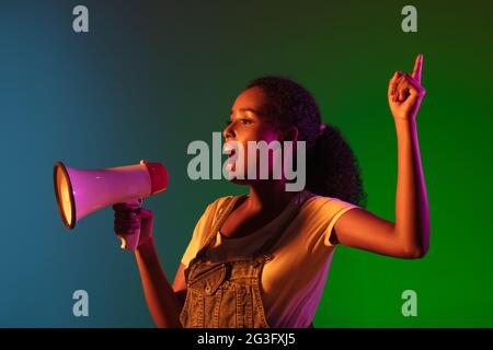 Latino junge Frau isoliert auf Studio Hintergrund in Neon. Konzept der menschlichen Emotionen, Gesichtsausdruck. Stockfoto