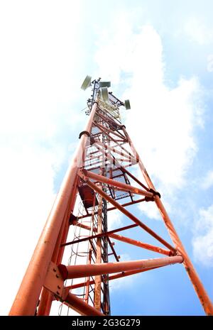 Telekommunikationsturm mit Antennen auf einem Hintergrund von blauem Himmel und Wolken. Intelligente Antennen übertragen 4G- und 5G-Mobilfunksignale an Verbraucher. Unten Stockfoto