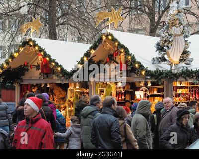 Menschen vor den Weihnachtsmarktständen am Universitätsplatz in Heidelberg, Deutschland. Stockfoto