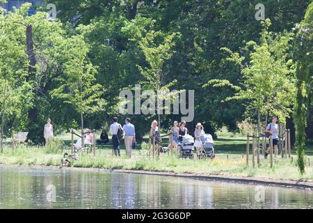 Wetter in Großbritannien, London: Am heißesten Tag des Jahres, an dem die Temperaturen voraussichtlich 29 Grad Celsius erreichen werden, nutzen Londoners Regent's Park, um sich abzukühlen oder die Sonne zu genießen. Einige gehen auf Tretboote, andere mieten sich einen Liegestuhl oder greifen auf eine Bank. Einige sind in Bikinis, andere voll bekleidet und sogar mit Gesichtsmasken im Freien. Eine kühlende Brise macht die Sonne erträglich, aber viele bleiben im Schatten. Anna Watson/Alamy Live News Stockfoto