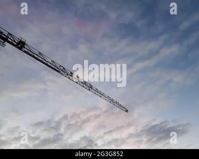 Low-Angle-Aufnahme eines Baukran gegen einen schönen Abendhimmel in Deutschland Stockfoto