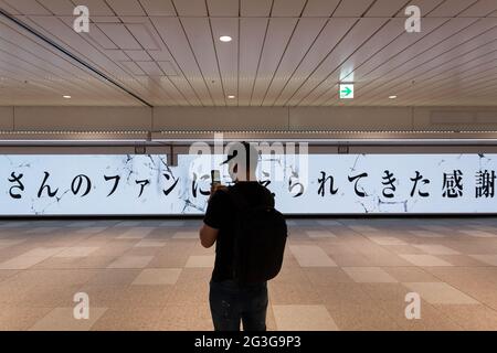 Tokio, Japan. Juni 2021. Ein Mann fotografiert einen großen LED-Bildschirm, der den Fans des Manga Attack on Titan, geschrieben und illustriert von hajime Isayama, für ihre Unterstützung in den 12 Jahren, in denen die Serie lief, dankt.der endgültige Band der Serie erschien am 9. Juni. Der Bildschirm verfügt über mehrere Figuren Büsten aus der Serie und ist 45.6 Meter breit, was ihn zu einem der größten Bildschirme macht, die jemals in Japan hergestellt wurden. Quelle: Damon Coulter/SOPA Images/ZUMA Wire/Alamy Live News Stockfoto