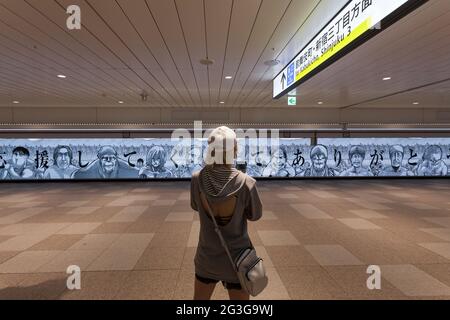 Tokio, Japan. Juni 2021. Eine Frau fotografiert einen großen LED-Bildschirm, der den Fans des Manga Attack on Titan, geschrieben und illustriert von hajime Isayama, für ihre Unterstützung in den 12 Jahren, in denen die Serie lief, dankt.der letzte Band der Serie erschien am 9. Juni. Der Bildschirm verfügt über mehrere Figuren Büsten aus der Serie und ist 45.6 Meter breit, was ihn zu einem der größten Bildschirme macht, die jemals in Japan hergestellt wurden. Quelle: Damon Coulter/SOPA Images/ZUMA Wire/Alamy Live News Stockfoto