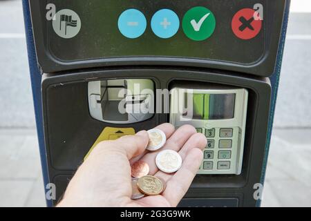 Hamburg, Deutschland. Juni 2021. ABBILDUNG - EINE Hand hält Euro-Münzen vor einem Parkscheinautomaten. Heute fand unter anderem eine Sitzung des Hamburger Parlaments zum Thema Parkgebühren statt. Quelle: Georg Wendt/dpa/Alamy Live News Stockfoto