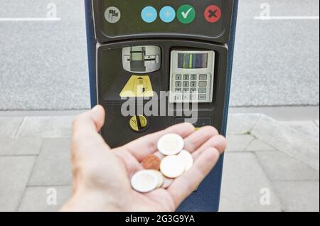 Hamburg, Deutschland. Juni 2021. ABBILDUNG - EINE Hand hält Euro-Münzen vor einem Parkscheinautomaten. Heute fand unter anderem eine Sitzung des Hamburger Parlaments zum Thema Parkgebühren statt. Quelle: Georg Wendt/dpa/Alamy Live News Stockfoto