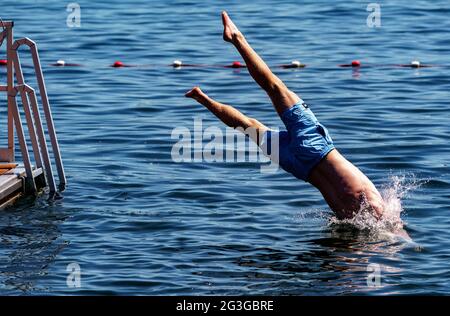 Kiel, Deutschland. Juni 2021. Ein junger Mann springt von einer Schwimmplattform in ein zum Schwimmen gesperrtes Gebiet der Kieler Förde. Auch im Norden beginnt der Sommer mit großer Hitze. Quelle: Axel Heimken/dpa/Alamy Live News Stockfoto