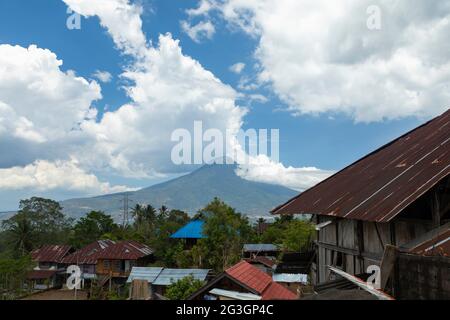 Blick auf den Vulkan Klabat, den höchsten Vulkan Sulawesis, und die umliegende Regenwaldlandschaft, in weiße Wolken gehüllt, Indonesien Stockfoto