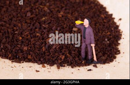 Miniaturarbeiter, der an gemahlenem Kaffee arbeitet Stockfoto