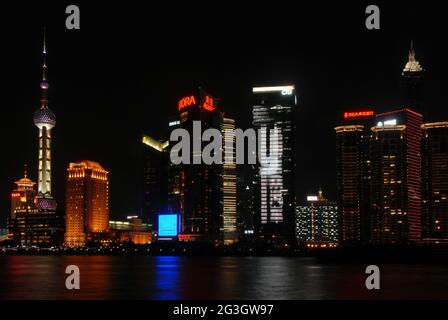 Pudong in Shanghai, China: Blick über den Huangpu vom Bund auf das Geschäftsviertel Pudong mit beleuchteten Türmen. Stockfoto