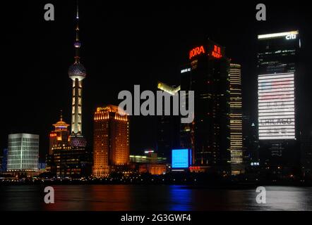 Pudong in Shanghai, China: Blick über den Huangpu vom Bund auf das Geschäftsviertel Pudong mit beleuchteten Türmen. Stockfoto