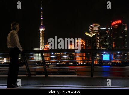 Pudong in Shanghai, China: Blick über den Huangpu-Fluss vom Bund in Richtung des Pudong-Geschäftsviertels mit Person. Stockfoto