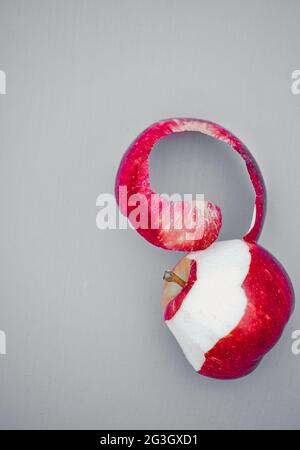 Direkt über dem teilweise geschälten roten Apfel isoliert auf grauem Hintergrund. Konzept der Ernährung, Ernährung, gesunde Ernährung Stockfoto