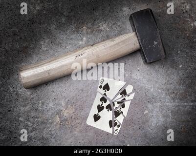 Hammer mit einer zerbrochenen Karte, neun Pik Stockfoto