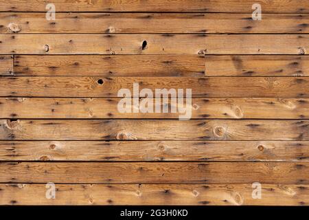 Braune Holzplankenwand mit Nägeln, Löchern und Knoten im Texturhintergrund Stockfoto