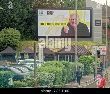 Glasgow, Schottland, Großbritannien, 16. Juni 2021. UK Wetter: Sommer Euro 2021 Fieber erschien in der Stadt mit guter Laune, da die Stadt ein normaleres Leben in der Sonne zeigte. Das riesige Gesicht von alan brazil, das am annieasland Cross über dem Biergarten im Freien thront. Quelle: Gerard Ferry/Alamy Live News Stockfoto