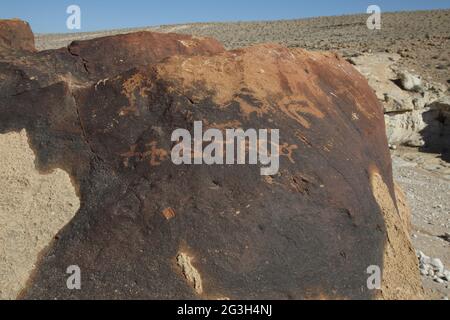 Uralte Kalksteinschnitzereien, wahrscheinlich nicht identifizierte frühe Form arabischer Schrift, die vor 2000 Jahren von Nabateanern auf der Patina geschrieben wurde. Stockfoto