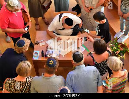 16. Juni 2021, Thüringen, Mühlhausen: Torah-Schreiber Reuven Yaakobov (oben, M) arbeitet an einer neuen Tora-Schriftrolle in der Synagoge, die von den protestantischer und katholischer Kirche als Geschenk gemacht wird. Seit 2019 schreibt der speziell ausgebildete Berliner Rabbiner die Tora-Schriftrolle mit Stift und Tinte von Hand. Am Ende wird es 304,805 Buchstaben haben. Die neue Tora-Schriftrolle für die Jüdische Gemeinde Thüringen wird im September 2021 mit einem großen Fest in die Synagoge in Erfurt gebracht. Foto: Martin Schutt/dpa-Zentralbild/dpa Stockfoto