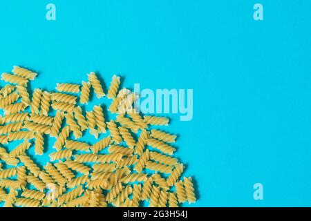 Pasta in Form von Spiralen auf blauem Hintergrund. Draufsicht. Stockfoto