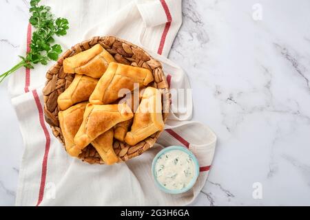 Gebratene Empanadas mit Koriander, Fleisch, Ei, Tomaten und Chilisauce auf weißem Hintergrund. Konzept des lateinamerikanischen und chilenischen Unabhängigkeitstages. Stockfoto