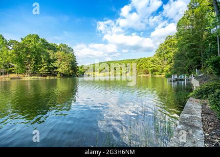 Das malerische Panorama des Lake Dartmoor in Tennessee zeigt eine sehr ruhige, glasige Seenoberfläche mit reichen, gesunden Eichen, die die Küste säumen. Stockfoto