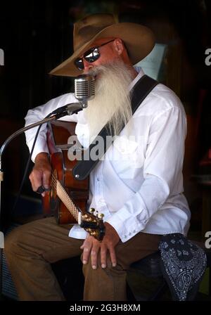 Johnny Lloyd, ein bekannter lokaler Straßenmusiker und Straßenmusiker, tritt auf einem Bürgersteig in Santa Fe, New Mexico, auf. Stockfoto