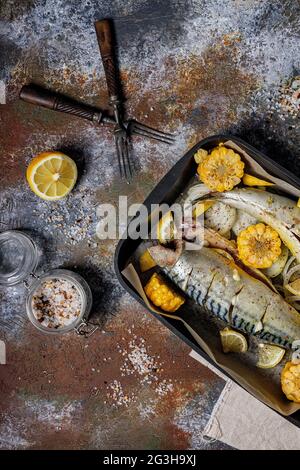 Marinierte Makrele mit Gemüse. Salzwasserfisch mit Gewürzen und Gemüse in einer gusseisernen Backform auf rustikalem Hintergrund gesund und lecker seaf Stockfoto