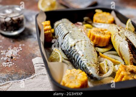 Marinierte Makrele mit weichem Brennpunkt und Gemüse. Salzwasserfisch mit Gewürzen und Gemüse in einer gusseisernen Backform auf rustikalem Hintergrund. Gesund und Stockfoto