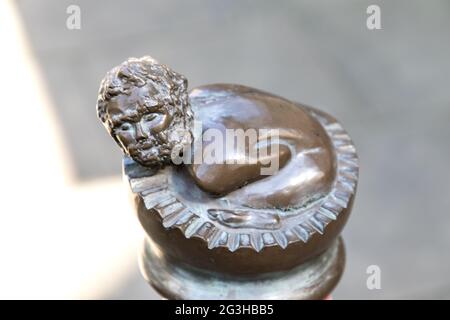 Bronzeskulptur von Peter, dem wilden Jungen, Kind, Mann, auf einem Poller in der Bridewell Alley Norwich. Stockfoto