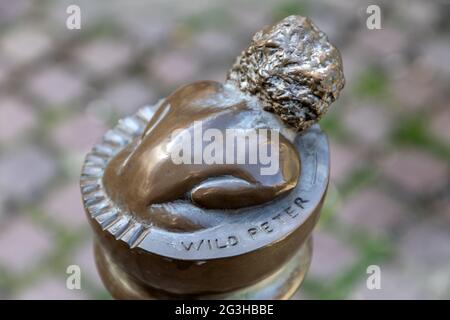 Bronzeskulptur von Peter, dem wilden Jungen, Kind, Mann, auf einem Poller in der Bridewell Alley Norwich. Stockfoto