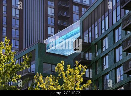 Die Morgensonne erhellt den Sky Pool in der Londoner Embassy Gardens-Anlage in Vauxhall. Der Pool erstreckt sich zwischen den Dächern von zwei 10-stöckigen Blöcken. Stockfoto