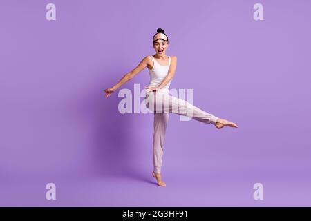 In voller Länge Körpergröße Foto von Mädchen tun Stretching-Übungen am Morgen isoliert pastelllila Farbe Hintergrund Stockfoto