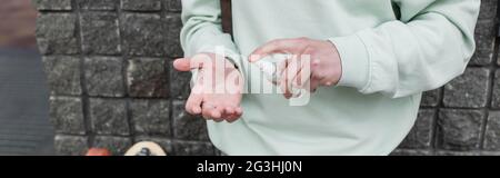 Beschnittene Ansicht des Mannes, der Desinfektionsmittel auf die Hand trug, Banner Stockfoto