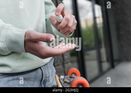 Beschnittene Ansicht des Mannes, der Desinfektionsmittel auf die Hand applyte Stockfoto