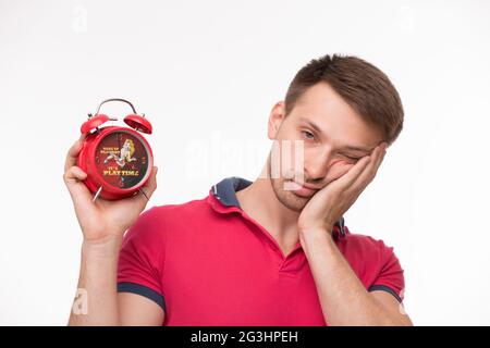 Junger Mann mit Wecker Stockfoto