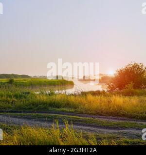 Sonnenaufgang im Nebel auf einem kleinen Fluss Stockfoto