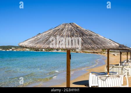 Strohschirm am Xifara Strand, einem kleinen und ruhigen Strand in der Bucht von Naoussa auf der Insel Paros, Kykladen, Griechenland Stockfoto