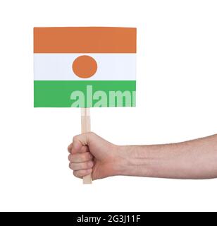 Hand hält kleine Karte - Flagge von Niger Stockfoto