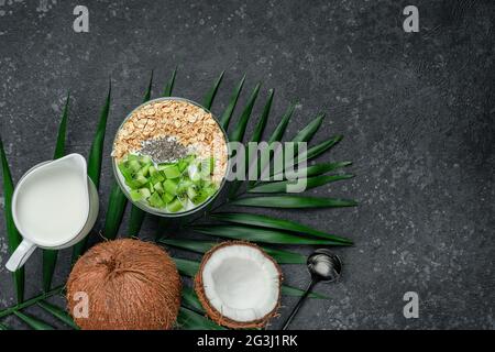 Haferflockenschale mit Kokosmilch, Kiwi und Chia-Samen, Platz zum Kopieren. Vegetarisches Speisekonzept. Stockfoto