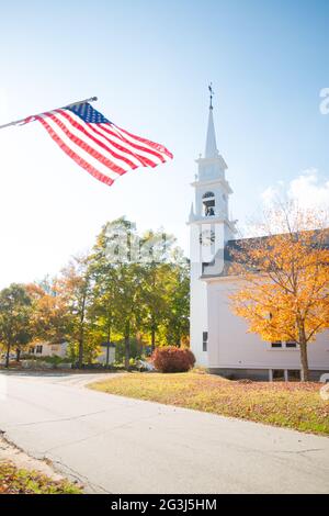 Kirche und amerikanische Flagge im Herbst Laub, Centre Sandwich, New Hampshire Stockfoto