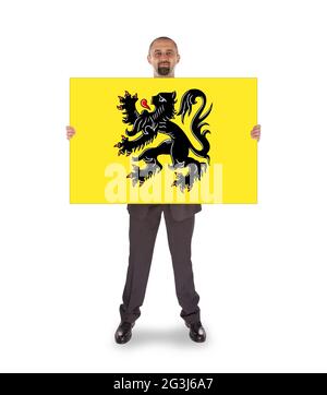 Lächelnder Geschäftsmann mit einer großen Karte, Flagge von Flandern Stockfoto