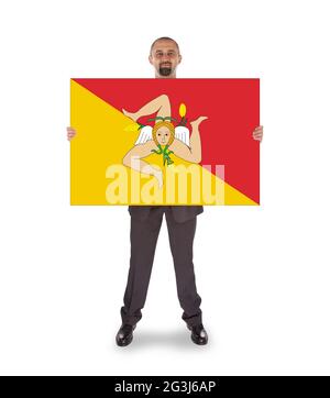 Lächelnder Geschäftsmann mit einer großen Karte, Flagge Siziliens Stockfoto