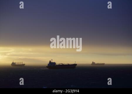 Landschaft, Meereslandschaft. Frachtschiffe, nach dem Abflug, auf See in den Sonnenuntergang zu öffnen. Stockfoto